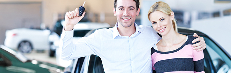auto loan rates image of happy couple with car keys in dealership
